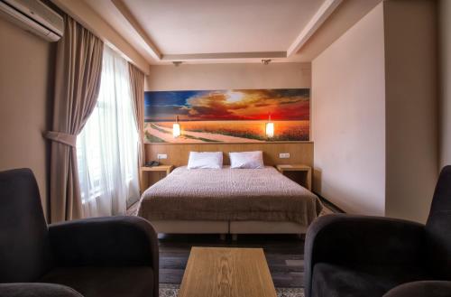 a hotel room with a bed and a painting on the wall at Hotel Lirak in Tetovo
