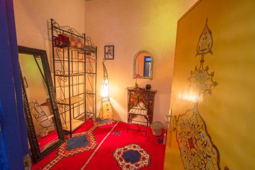 a room with a red rug and a mirror at Maison du Soleil in Tiznit