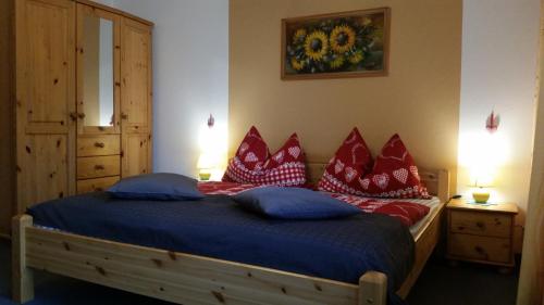 a bedroom with a bed with red and blue pillows at Haus Angelika - bed & breakfast - Innsbruck/Igls in Innsbruck