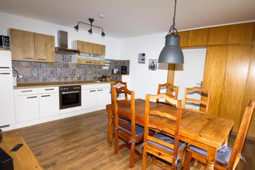 cocina con mesa de madera y comedor en Ferienhaus "Kleiner Onkel" en Honerath