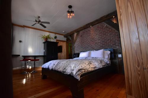a bedroom with a bed with a brick wall at Gîte TerreCiel in Baie-Saint-Paul