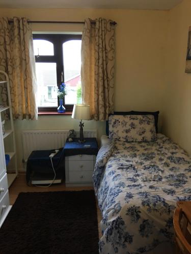 um pequeno quarto com uma cama e uma janela em The Cedars House B&B em Nuneaton