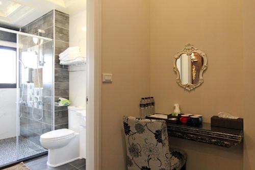 a bathroom with a toilet and a mirror on the wall at Fardo Homestay in Hualien City