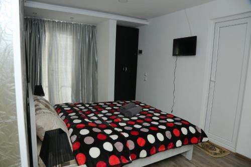 1 dormitorio con edredón negro y rojo en una cama en Hotel Elma, en Kutaisi