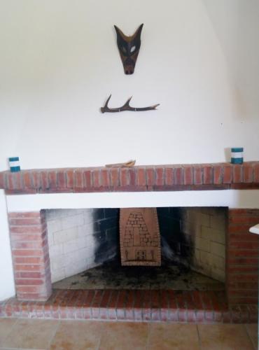 a brick fireplace with a mask on the wall at Casa del Cervo in Ingurtosu