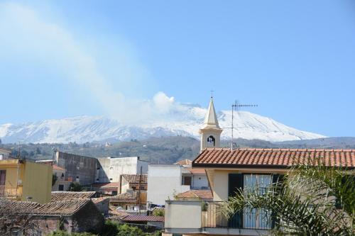 a town with a church and a mountain in the background at B&B Villa San Leonardo in Mascali