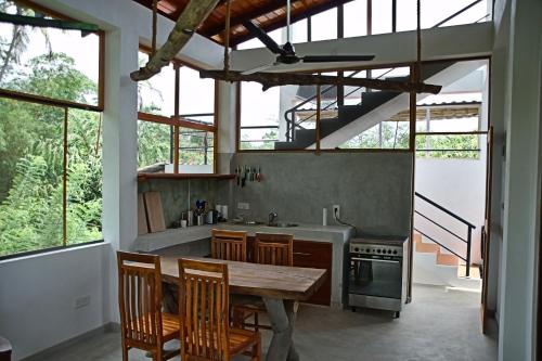 a kitchen with a wooden table and some windows at Villa Lanka Relax in Hikkaduwa