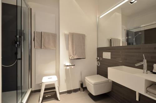 ein Bad mit einem WC, einem Waschbecken und einer Dusche in der Unterkunft Asante-Design-Apartment Deluxe - very central in München