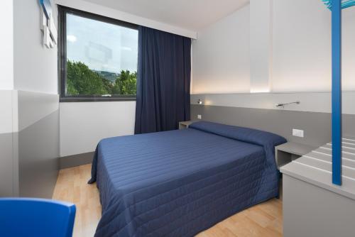 a bedroom with a blue bed and a window at Hotel Martini in Verona