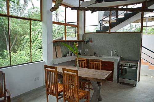 a kitchen with a wooden table and some windows at Villa Lanka Relax in Hikkaduwa
