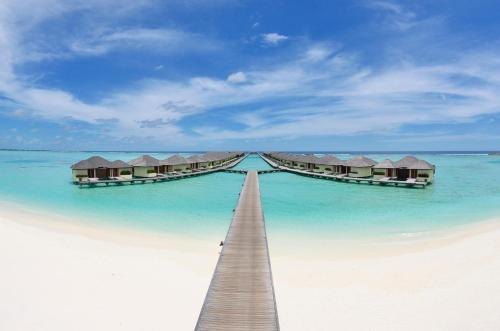 a row of huts on a beach in the water at Villa Nautica Paradise Island Resort in North Male Atoll