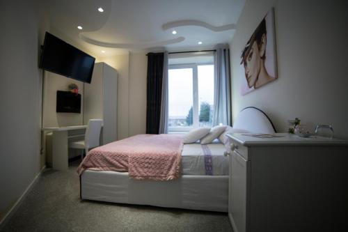 een slaapkamer met een bed, een bureau en een raam bij BnB Notte Stellata in Savigliano