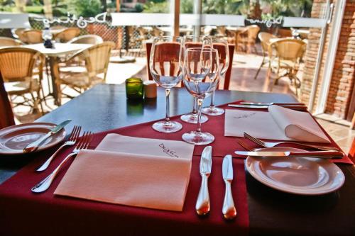 a table with a red table cloth with glasses and silverware at Jardim da Meia Praia Resort in Lagos
