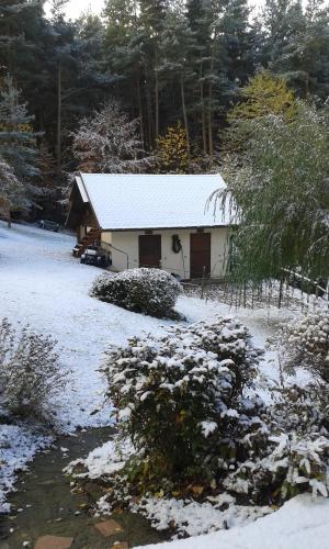 a barn covered in snow next to a stream at Romantic Studio Vacances in Labaroche