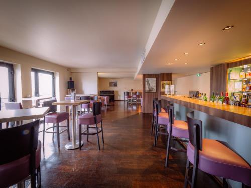 a restaurant with tables and chairs and a bar at Hotel du Casino in Saint-Valéry-en-Caux