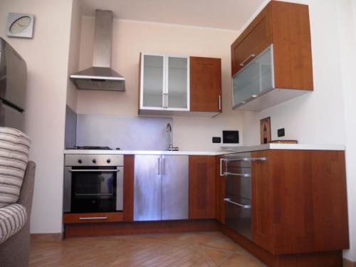 a kitchen with wooden cabinets and stainless steel appliances at Fata Morgana Suite in Reggio Calabria