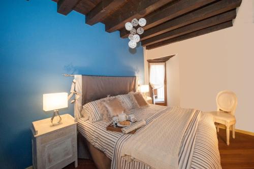 - une chambre avec un grand lit et un mur bleu dans l'établissement Casa Torrazzo, à Pisogne