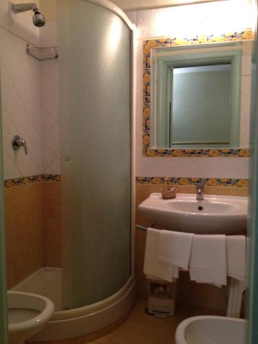 a bathroom with a sink and a mirror and a toilet at Hotel Ristorante Amitrano in Pompei