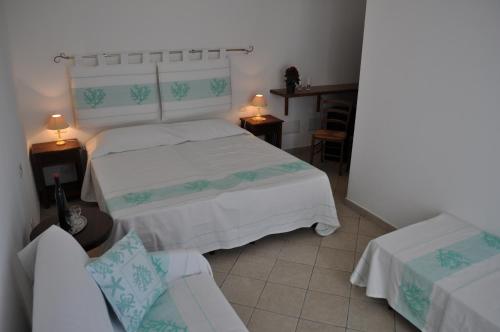 a bedroom with two beds and a couch at La Striscia Larga in San Pasquale