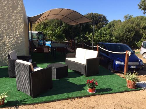 a group of chairs and a gazebo on grass at La Striscia Larga in San Pasquale
