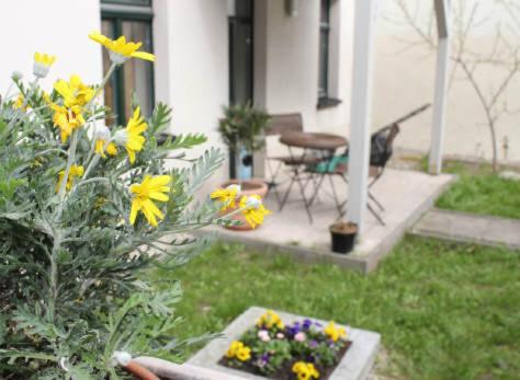 a garden with flowers and a bird in the yard at Internationales Gästehaus Leipzig in Leipzig