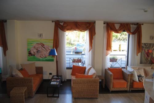 a living room with couches and chairs and windows at Hotel Europa in San Bartolomeo al Mare