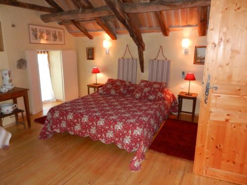 - une chambre avec un lit et une couette rouge dans l'établissement La Belle Poule - FAVEROLLE, à Villefranche-de-Rouergue