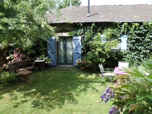 einen Garten mit einer blauen Tür sowie einem Tisch und Stühlen in der Unterkunft La Belle Poule - SEBRIGHT in Villefranche-de-Rouergue
