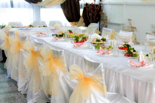 a row of white tables with plates of food on them at 4 Seasons in Boryspilʼ