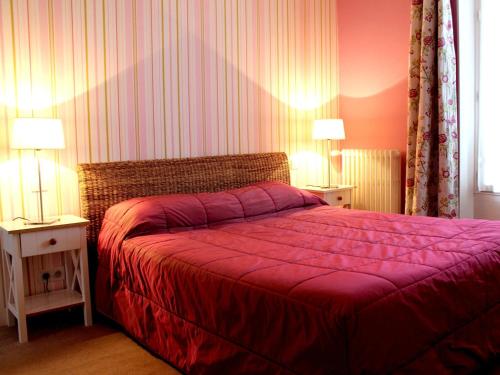 IlliersにあるHotel Les Aubépinesのベッドルーム1室(赤いベッドカバー、ランプ2つ付)