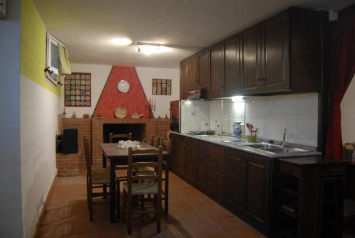 a kitchen with a table and a kitchen with a fireplace at B&B Filomena in Santa Giusta