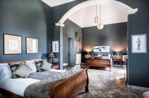 Un dormitorio con una cama y un piano en una habitación en Palazzo Muro Leccese Relais de Charme & Wellness, en Muro Leccese