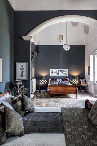 a living room with a couch and a bed at Palazzo Muro Leccese Relais de Charme & Wellness in Muro Leccese