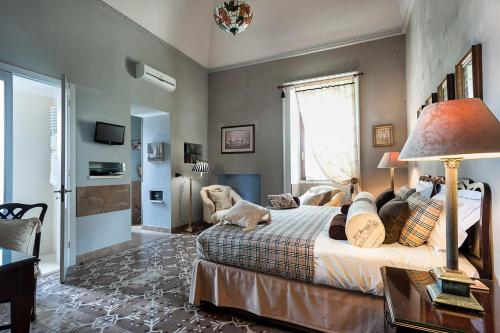 a bedroom with a bed and a table and a lamp at Palazzo Muro Leccese Relais de Charme & Wellness in Muro Leccese