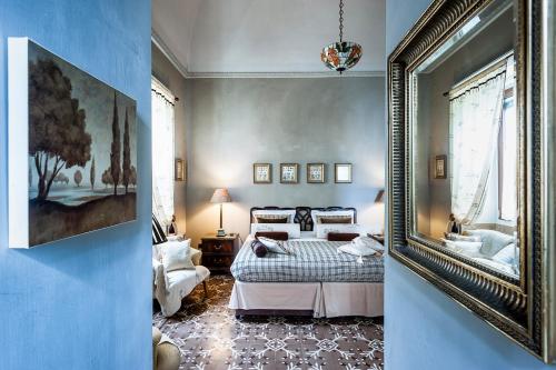 1 dormitorio con cama y espejo en Palazzo Muro Leccese Relais de Charme & Wellness, en Muro Leccese
