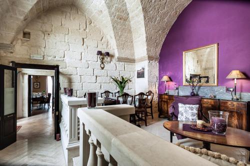 a living room with purple walls and a table at Palazzo Muro Leccese Relais de Charme & Wellness in Muro Leccese