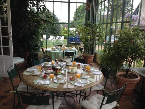 - une table avec des assiettes de nourriture sur la terrasse dans l'établissement Clos Saint Nicolas, à Neauphle-le-Château