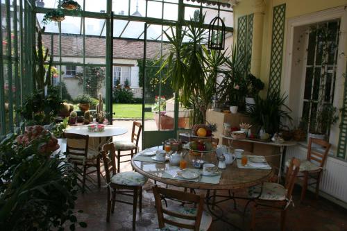 a room with tables and chairs and a room with plants at Clos Saint Nicolas in Neauphle-le-Château