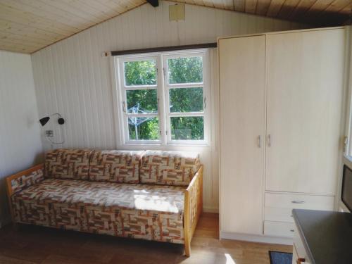 - un salon avec un canapé et une fenêtre dans l'établissement Lyngholt Family Camping & Cottages, à Allinge