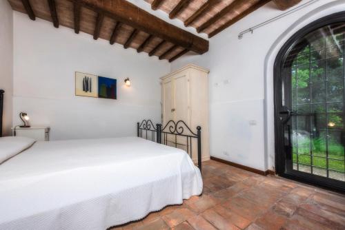 a bedroom with a bed and a large window at Agriturismo La Collina Dei Lecci in San Gimignano