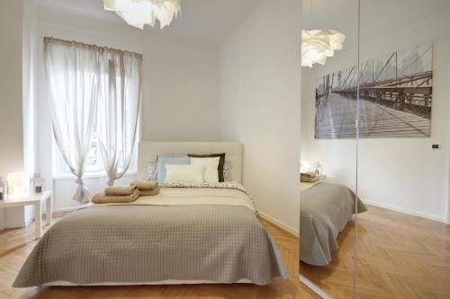 ミラノにあるMilanRentals - Mameli Apartmentの白いベッドルーム(ベッド1台、窓付)
