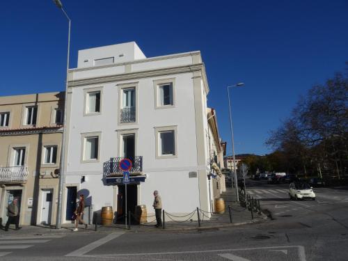 a white building with people standing in front of it at Alojamentos Casa Facha Menta in Portalegre