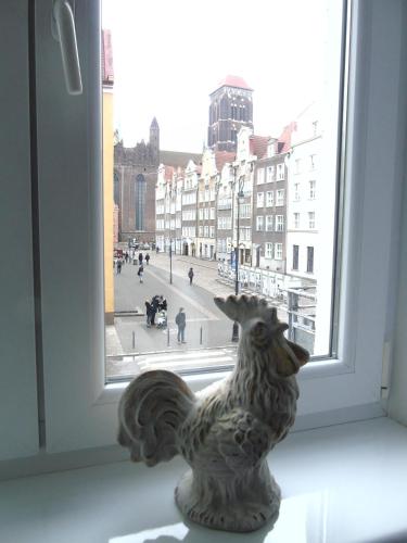 a statue of a bird sitting on a window sill at Apartament MARIA in Gdańsk