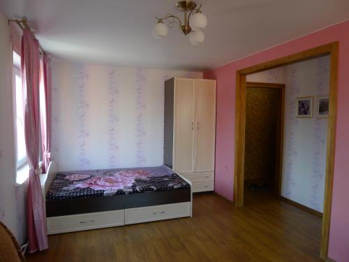 ノヴォシビルスクにあるApartments on Tsvetnoy proyezd 27のピンクの壁のベッドルーム1室(ベッド1台付)