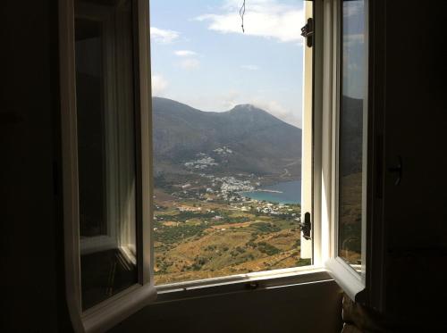 an open window with a view of a mountain at Plori Studios and Apartments in Aegiali