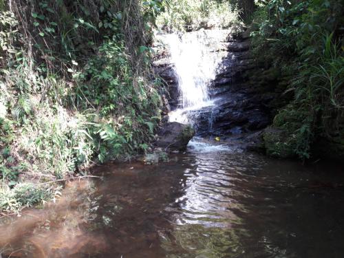 a waterfall in the middle of a river at Cabañas La Honda in Guatapé