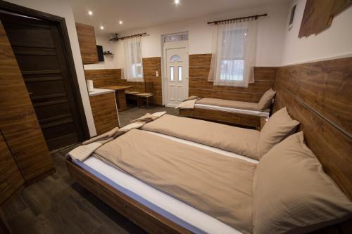 a room with two beds in a room with a bathroom at Relax Apartmanház in Mórahalom