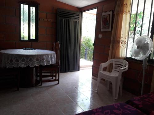 a living room with a table and chairs and a fan at Cabañas La Honda in Guatapé