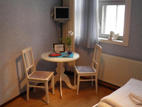 een kamer met een tafel, 2 stoelen en een bed bij Ferienhaus Wiethüchter in Lübeck