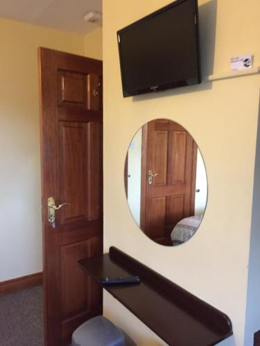 a mirror in a room with a door and a tv at Maureen's Bed and Breakfast in Tralee